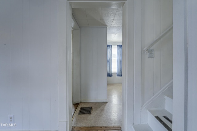 hallway with visible vents and wood walls