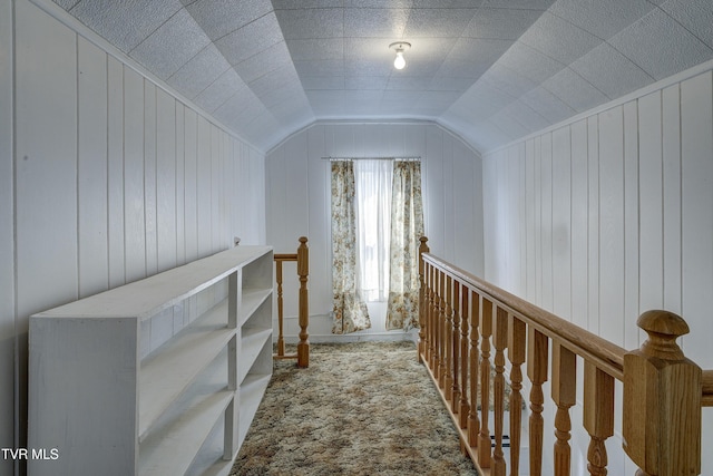 hallway featuring carpet floors, an upstairs landing, and vaulted ceiling