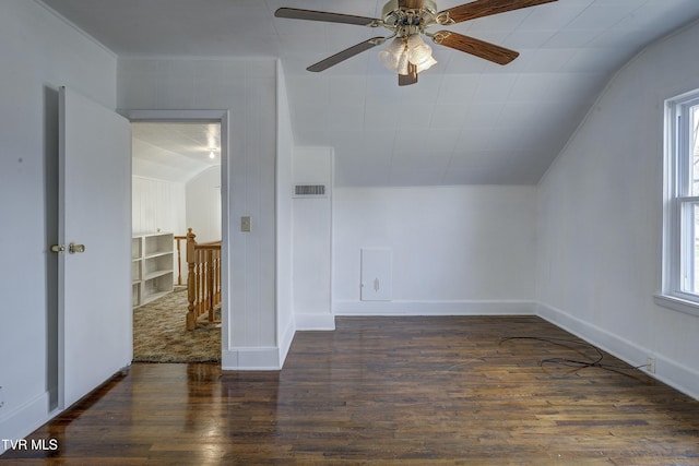 additional living space with wood finished floors, baseboards, visible vents, ceiling fan, and vaulted ceiling