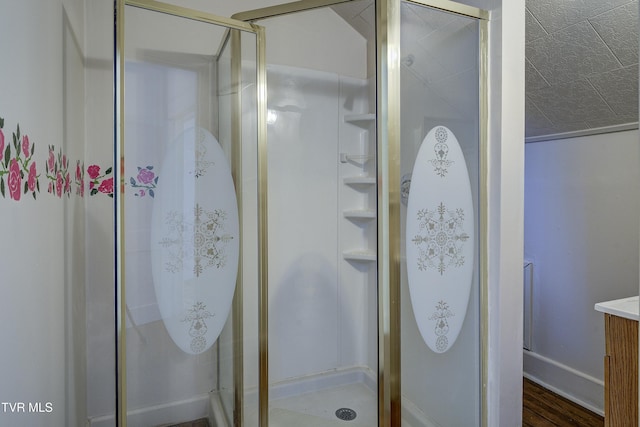 full bathroom with a stall shower, vanity, and wood finished floors