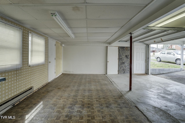 garage with wallpapered walls and a baseboard radiator