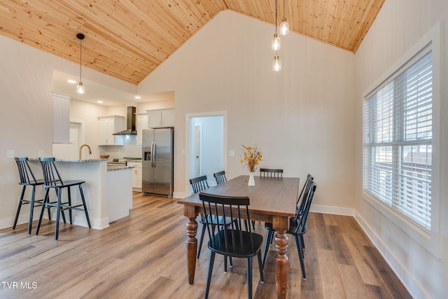 dining area featuring baseboards, wooden ceiling, high vaulted ceiling, and light wood-style floors