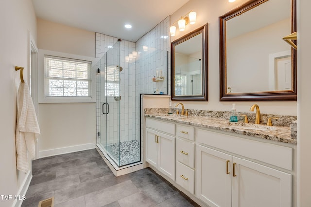 bathroom featuring double vanity, a stall shower, visible vents, and a sink