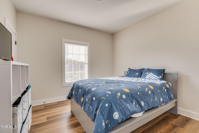 bedroom with baseboards and wood finished floors