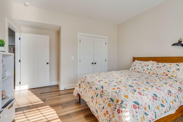 bedroom with a closet, baseboards, and wood finished floors