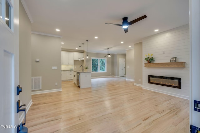 129 Stratton Pl, Kingsport, TN 37663 - unfurnished living room with ceiling fan, a fireplace, ornamental molding, light wood-style floors, and recessed lighting