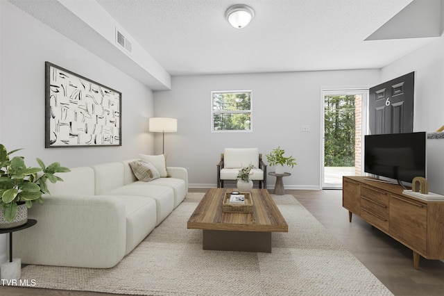 living room featuring plenty of natural light, wood finished floors, and visible vents