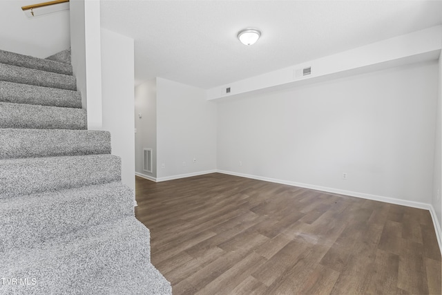 interior space with visible vents, stairs, baseboards, and wood finished floors