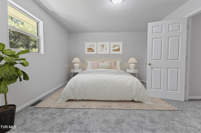 bedroom featuring baseboards, carpet, and a textured ceiling