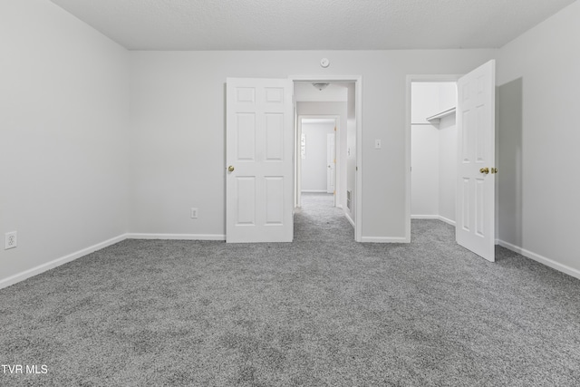 unfurnished bedroom featuring baseboards, a textured ceiling, and carpet