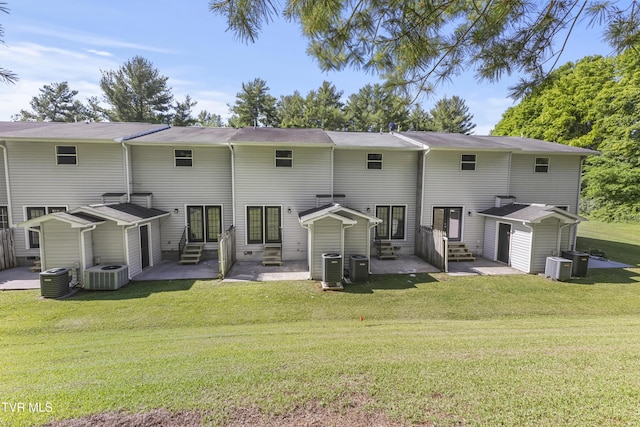 rear view of property with central air condition unit, a lawn, and entry steps