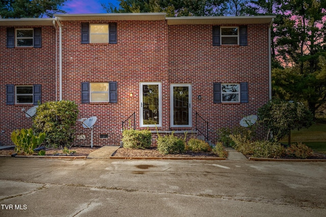 view of front of house with brick siding and crawl space