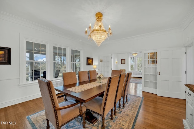 dining room featuring baseboards, a notable chandelier, wood finished floors, and crown molding