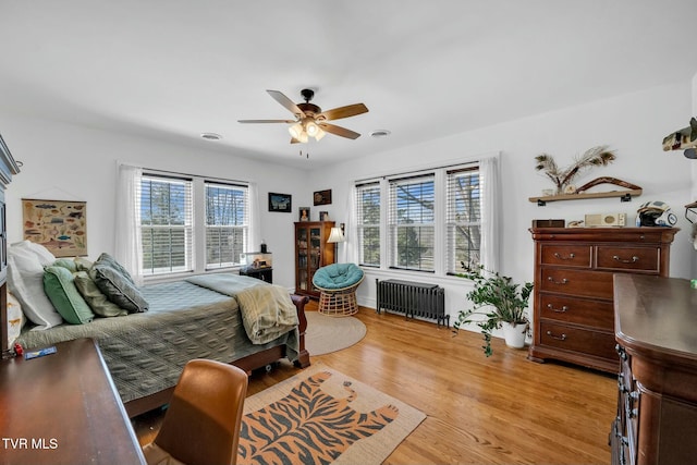 bedroom featuring radiator, a ceiling fan, and light wood-style floors