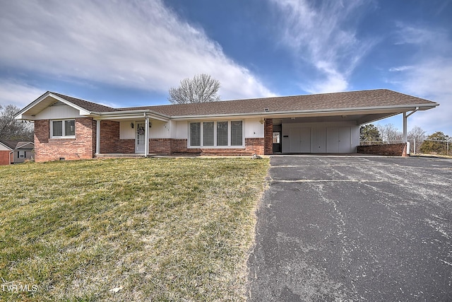 ranch-style home with brick siding, aphalt driveway, an attached carport, and a front yard