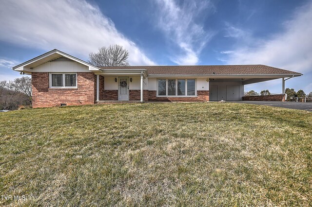 ranch-style house featuring a carport, aphalt driveway, brick siding, and a front lawn