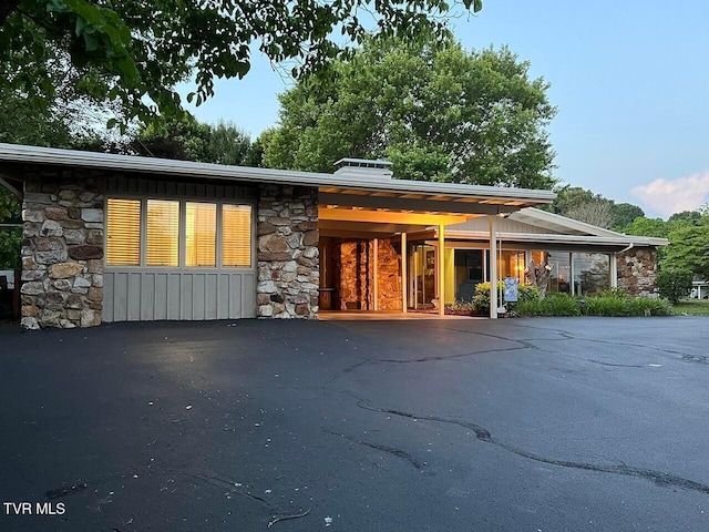 back of property featuring stone siding