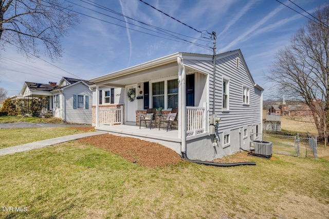 view of front of property featuring a front lawn, fence, covered porch, cooling unit, and a gate