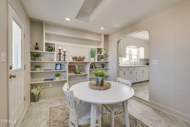 dining room with built in features, recessed lighting, and arched walkways