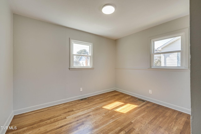 spare room with visible vents, baseboards, a healthy amount of sunlight, and light wood finished floors