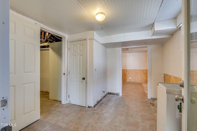 finished below grade area with wooden ceiling, wooden walls, and a wainscoted wall