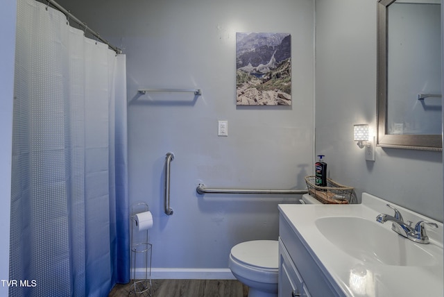 bathroom with baseboards, toilet, a shower with shower curtain, wood finished floors, and vanity