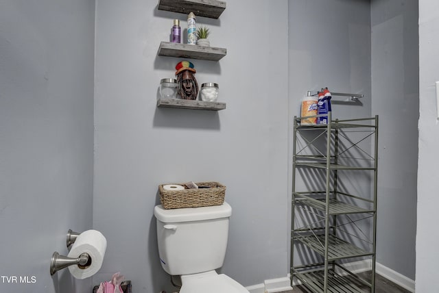 bathroom with toilet and baseboards