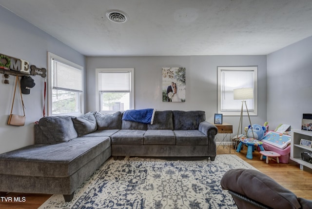 living area with visible vents and wood finished floors