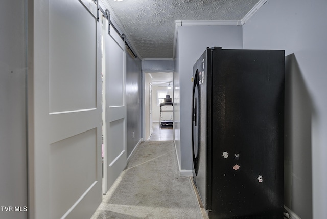 hall featuring a barn door, crown molding, carpet floors, and a textured ceiling