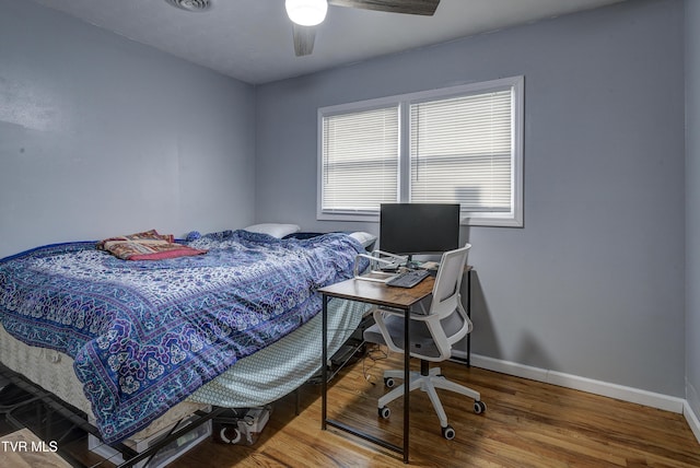 bedroom with visible vents, wood finished floors, baseboards, and ceiling fan