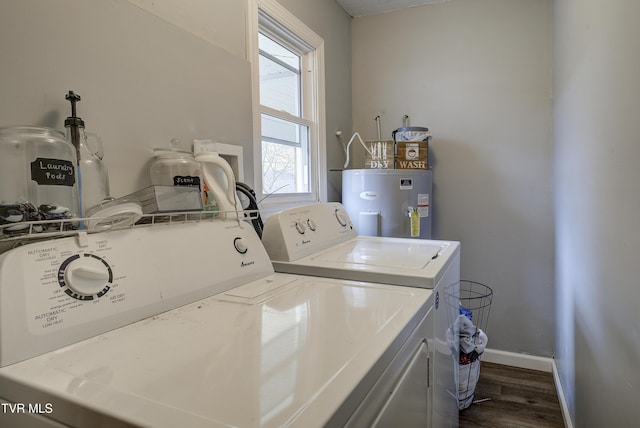 washroom featuring water heater, laundry area, dark wood-type flooring, and separate washer and dryer