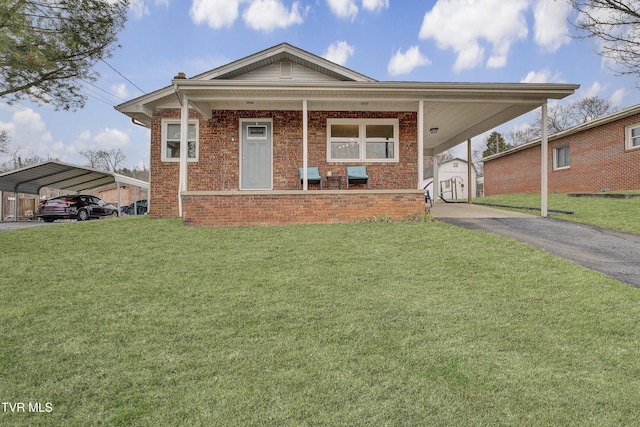 view of front facade with brick siding, aphalt driveway, a porch, a front yard, and a carport