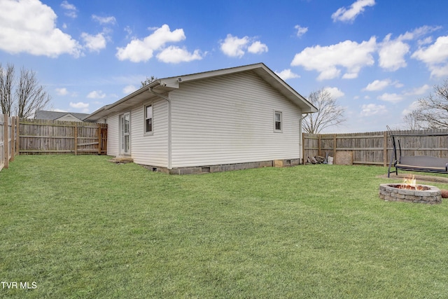 view of home's exterior featuring crawl space, a fire pit, a fenced backyard, and a yard