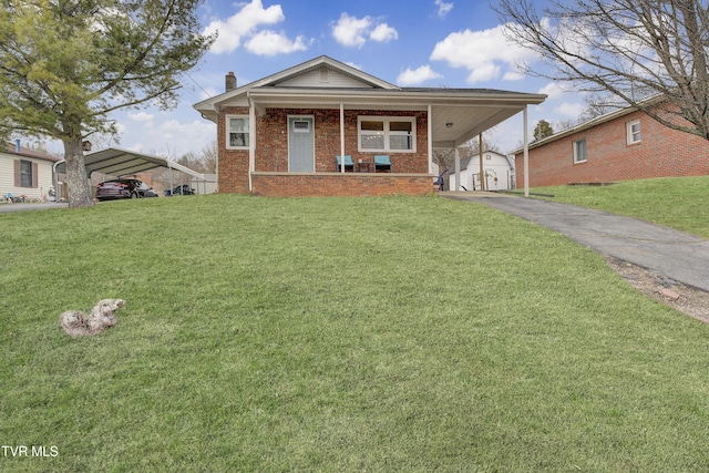 view of front of house with covered porch, a chimney, a front lawn, aphalt driveway, and brick siding