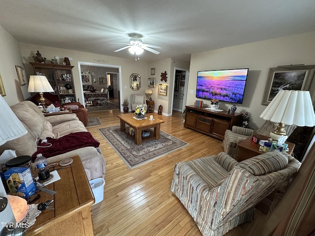 living room with a ceiling fan and light wood finished floors