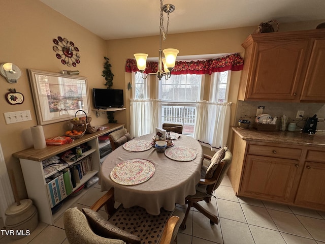 dining space featuring light tile patterned floors and a chandelier