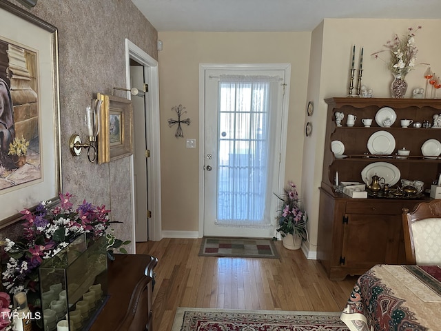 foyer with baseboards and light wood finished floors