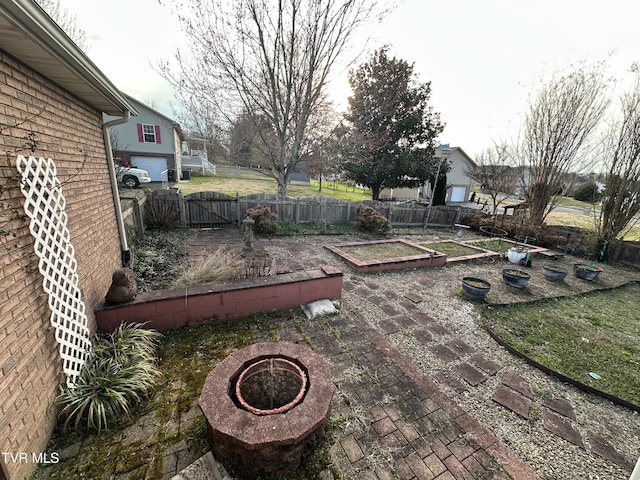 view of yard with a patio, a fire pit, a vegetable garden, and fence