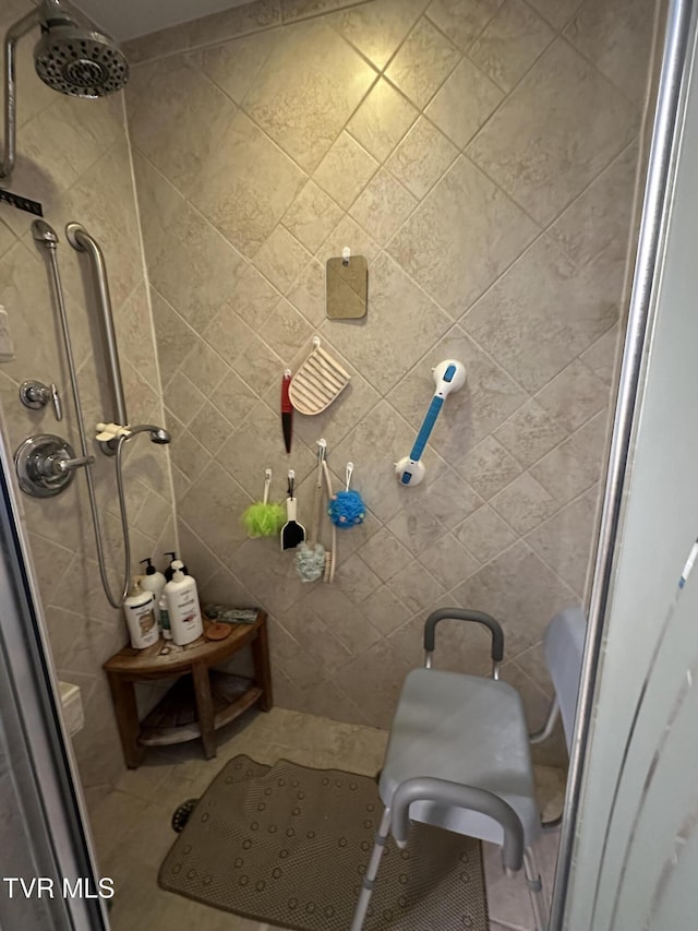 full bathroom featuring a stall shower and tile walls