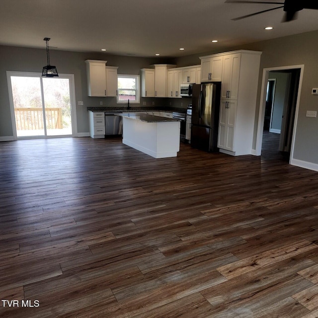 kitchen featuring dark countertops, white cabinetry, stainless steel appliances, and dark wood-style flooring