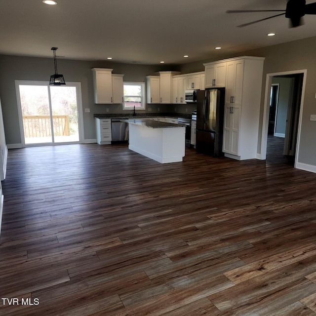 kitchen featuring dark countertops, dark wood-style floors, white cabinetry, recessed lighting, and stainless steel appliances