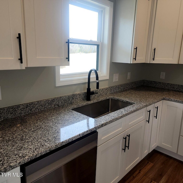 kitchen featuring a sink, light stone counters, dishwasher, and white cabinetry