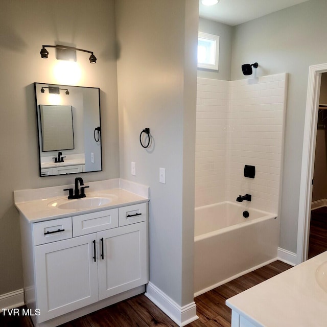 full bathroom featuring shower / bathing tub combination, baseboards, wood finished floors, and vanity