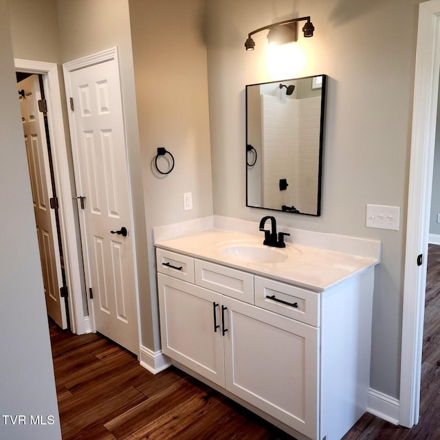 bathroom with vanity, baseboards, and wood finished floors