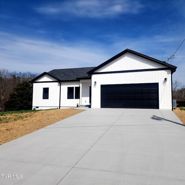 modern farmhouse featuring a garage, central AC unit, and driveway