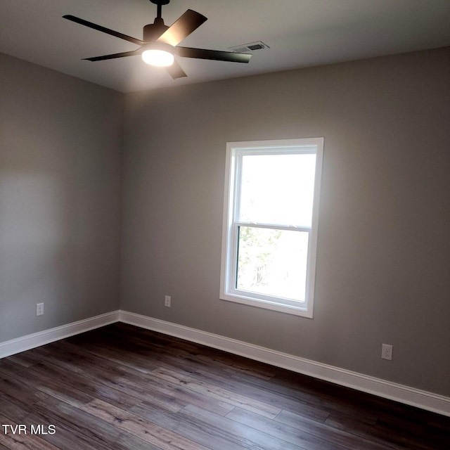 empty room featuring baseboards, dark wood-type flooring, and ceiling fan