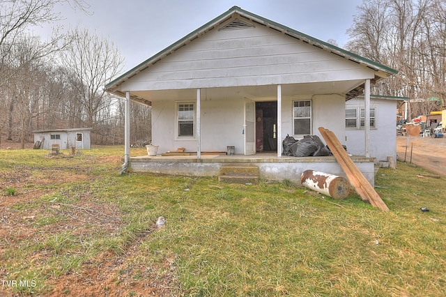 bungalow-style house with covered porch, stucco siding, and a front lawn