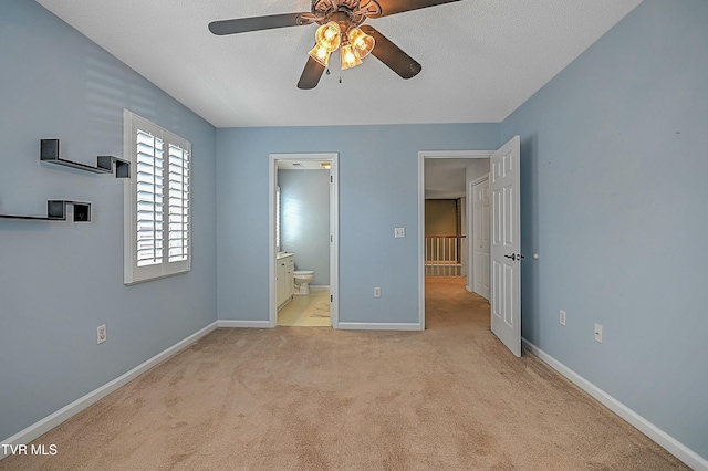 unfurnished bedroom featuring connected bathroom, baseboards, a textured ceiling, and carpet flooring