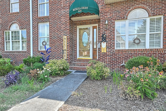 property entrance featuring brick siding