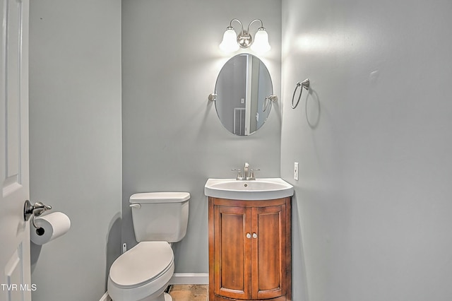 bathroom with vanity, toilet, and baseboards